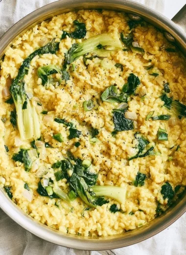 Bowl of creamy coconut rice garnished with herbs and spices for anti-inflammatory benefits.