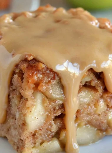 Slice of delicious Apple Dapple Cake with apples and nuts on a plate
