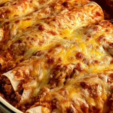 Cheesy beef and cheese enchiladas garnished with fresh cilantro