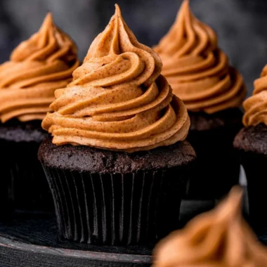 Cozy chocolate pumpkin cupcakes topped with creamy frosting and autumn spices.