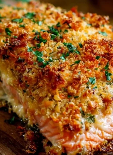 Crispy parmesan crusted baked salmon garnished with herbs on a plate