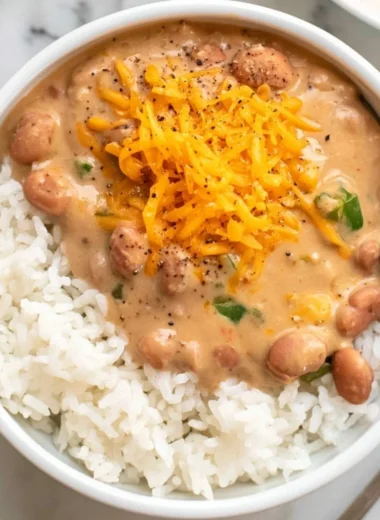 A bowl of cozy easy pinto beans garnished with herbs and spices