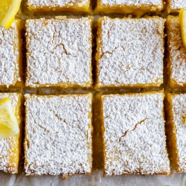 Delicious cozy lemon bars topped with powdered sugar, a slice of sunshine.
