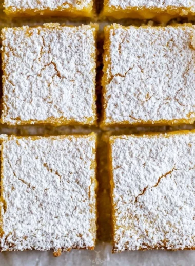 Delicious cozy lemon bars topped with powdered sugar, a slice of sunshine.