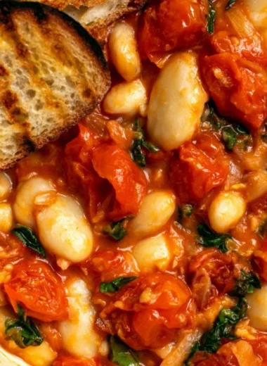 Creamy tomato basil butter beans stew in a bowl garnished with fresh basil.