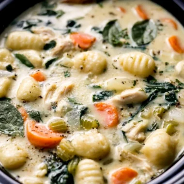 Bowl of creamy Crockpot Chicken Gnocchi Soup with vegetables and herbs