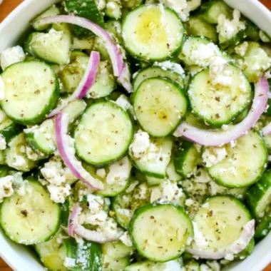 Fresh cucumber feta salad with herbs and olives in a bowl.