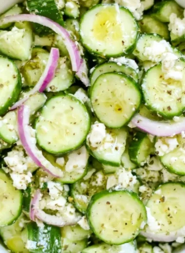 Fresh cucumber feta salad with herbs and olives in a bowl.