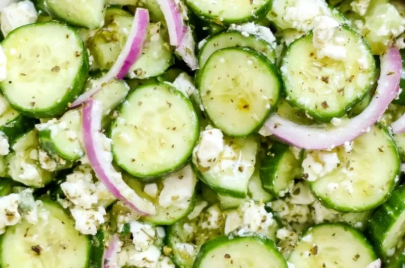 Fresh cucumber feta salad with herbs and olives in a bowl.