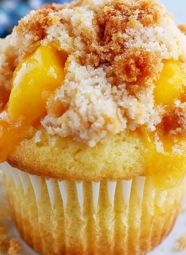 Delicious homemade peach cobbler muffins topped with crumble and peaches