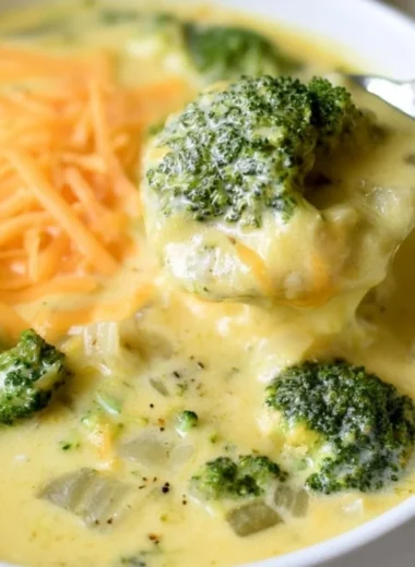 Bowl of easy keto broccoli cheese soup garnished with cheese and broccoli