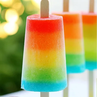 Colorful homemade rainbow popsicles in various fruity flavors