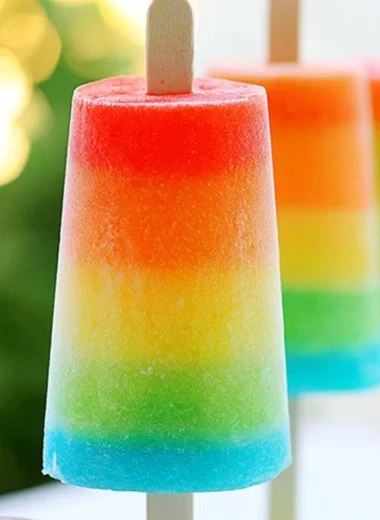 Colorful homemade rainbow popsicles in various fruity flavors