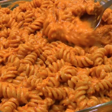 High protein creamy tomato pasta served in a bowl with fresh basil and parmesan.