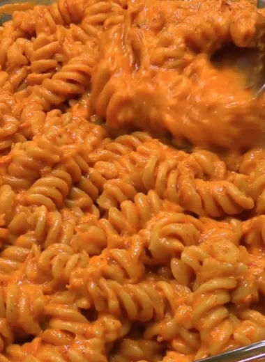 High protein creamy tomato pasta served in a bowl with fresh basil and parmesan.