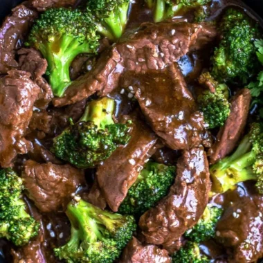 Slow cooked beef and broccoli served in a bowl with rice and sesame seeds