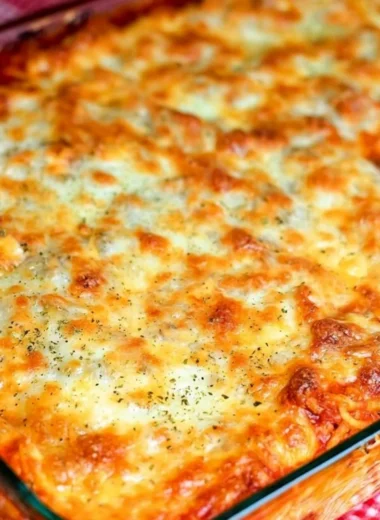 Delicious baked spaghetti dish topped with melted cheese and fresh herbs