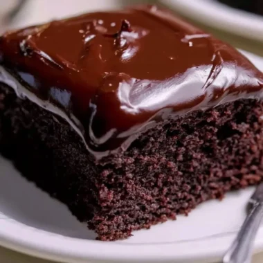Wacky Chocolate Cake topped with rich chocolate frosting and sprinkles