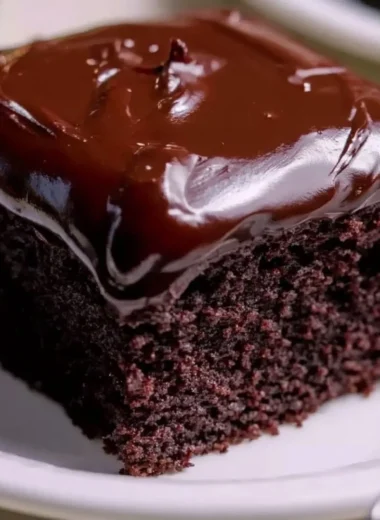 Wacky Chocolate Cake topped with rich chocolate frosting and sprinkles