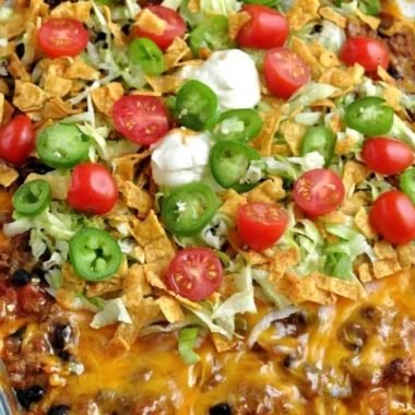 A delicious serving of Walking Taco Casserole topped with lettuce and cheese