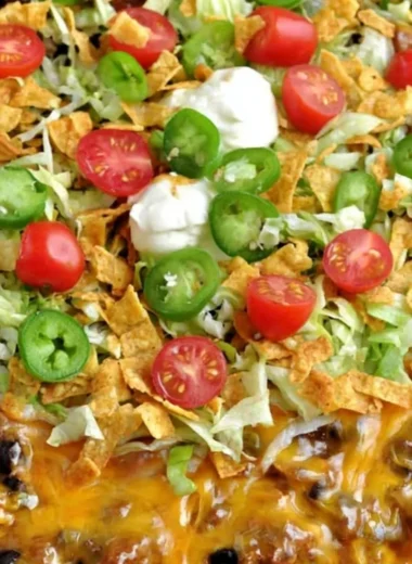 A delicious serving of Walking Taco Casserole topped with lettuce and cheese