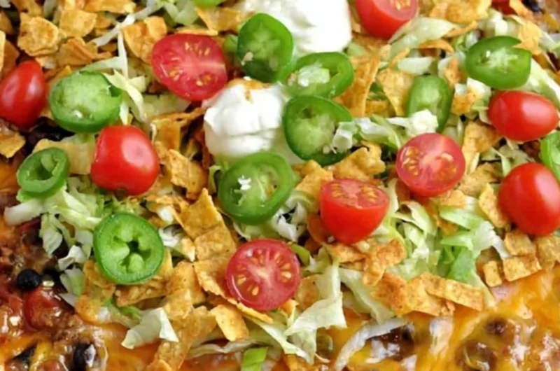 A delicious serving of Walking Taco Casserole topped with lettuce and cheese