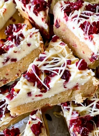 Homemade Starbucks Copycat Cranberry Bliss Bars decorated with icing and cranberries.
