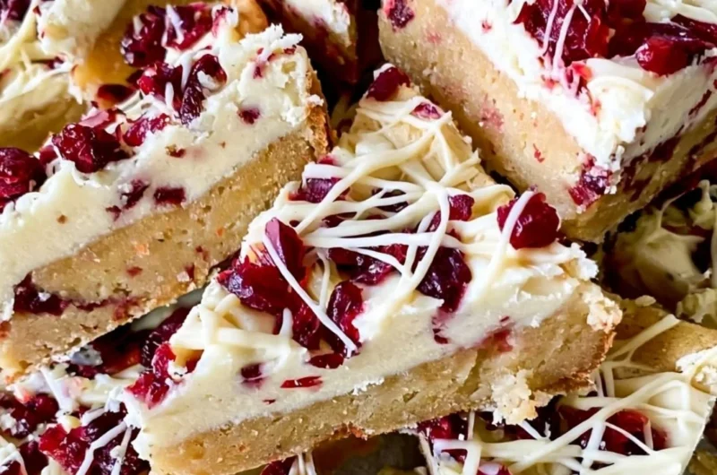 Homemade Starbucks Copycat Cranberry Bliss Bars decorated with icing and cranberries.
